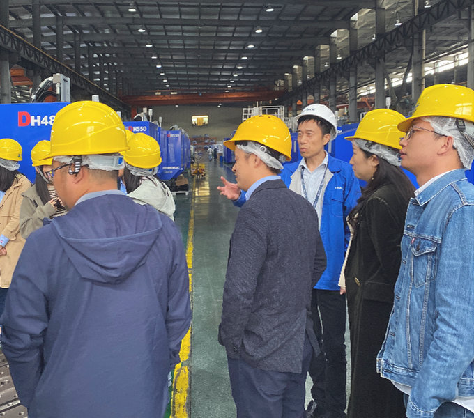 Factory visitors wearing safety helmets