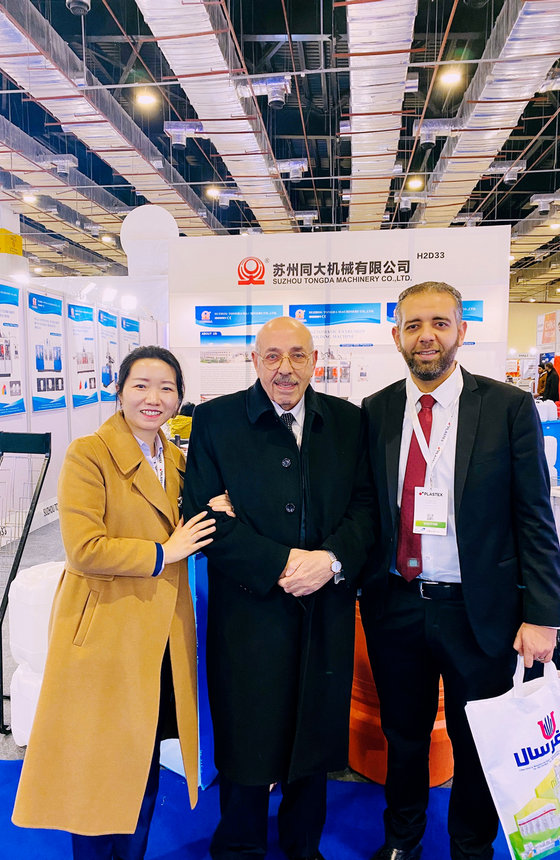 Three visitors at an exhibition booth