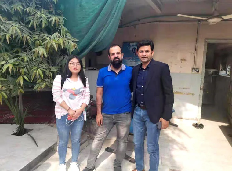 Three visitors outside a building