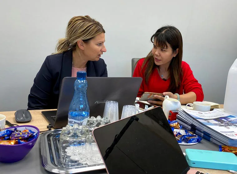 Two visitors discussing documents at a table