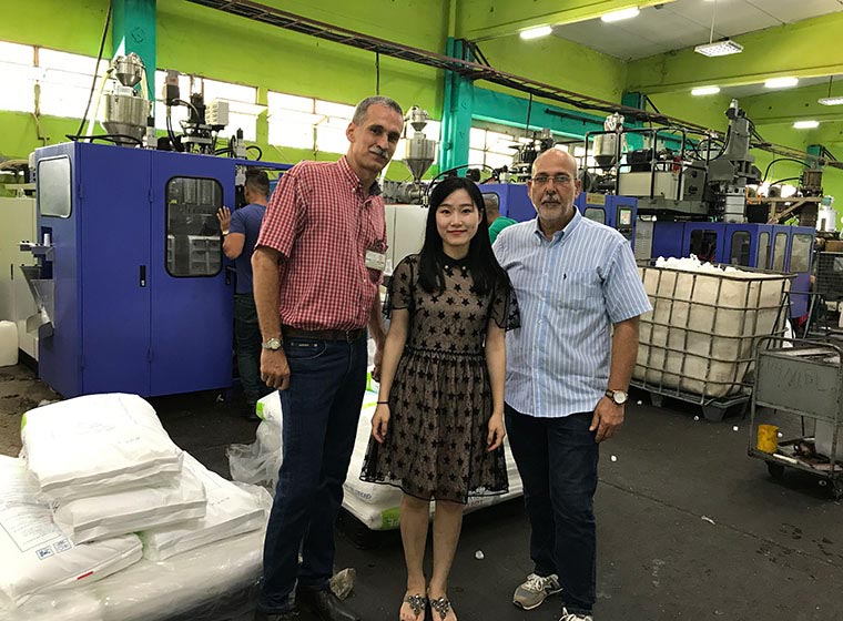 Visitors beside a blow molding machine
